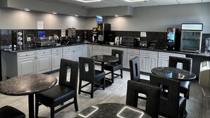 A modern kitchen area with granite countertops, built-in appliances, and bar seating. - Best Western Bolingbrook Hotel (Bolingbrook)
