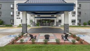 A modern building with a covered entrance, outdoor seating, and a wheelchair-accessible ramp. - Best Western Bolingbrook Hotel (Bolingbrook)