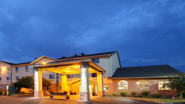 A multi-story hotel with a covered entrance and a parking lot.