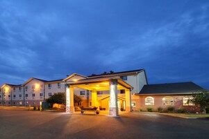 Um hotel de vários andares com entrada coberta e estacionamento.