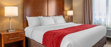 Edredón, escritorio y espacio para trabajar con laptop