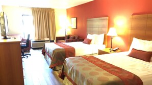 A hotel room with two beds, a desk, a chair, and a lamp. - Ramada by Wyndham Pearl/Jackson Airport (Pearl)