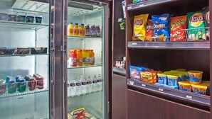 A vending machine stocked with various snacks and drinks, including soda, chips, and hot beverages. - Ramada by Wyndham Pearl/Jackson Airport (Pearl)