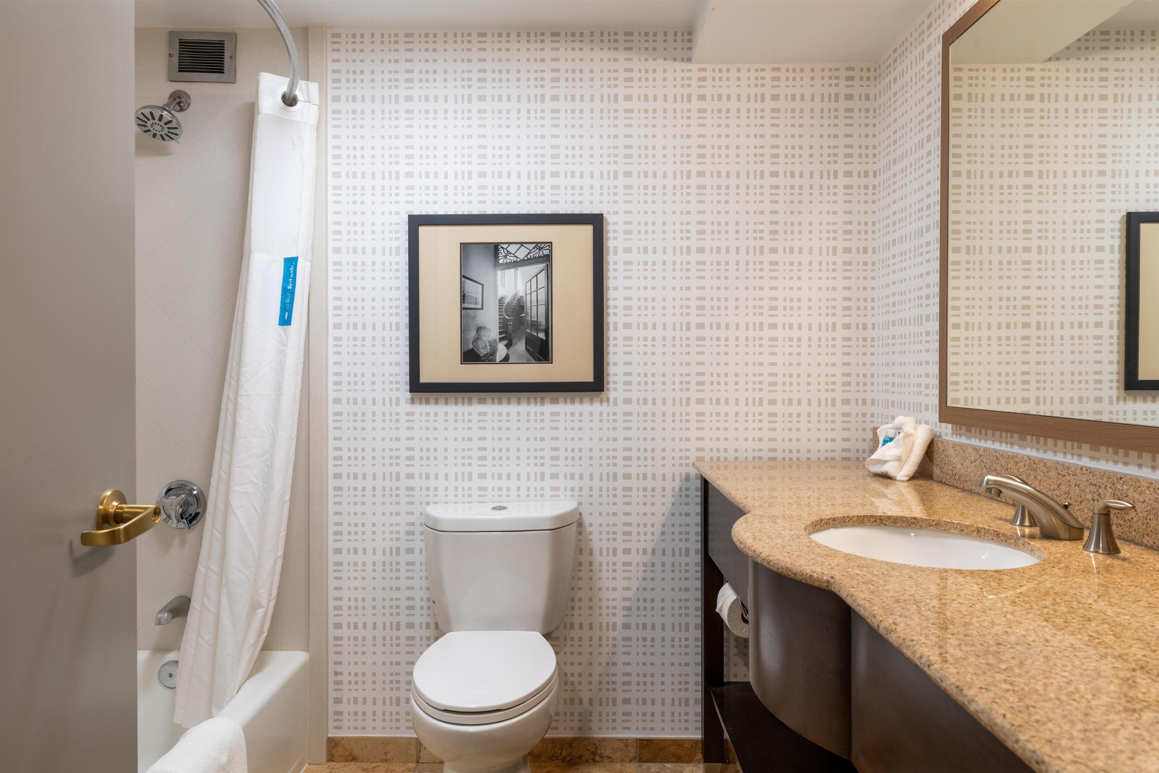 A bathroom with a toilet, sink, and shower.