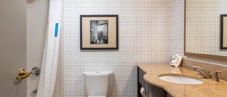 A bathroom with a toilet, sink, and shower.