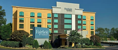 A Fairfield by Marriott hotel with a modern facade, multiple windows, and a prominent American flag.