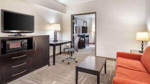 A hotel room with a flat-screen TV, a desk with a lamp, a sofa, and a microwave. - Best Western Mason Inn (Mason)
