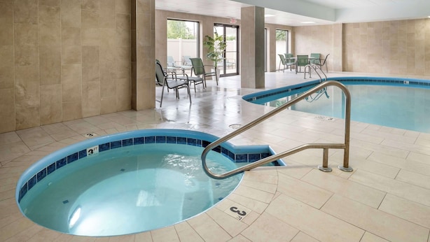 A swimming pool with a blue tiled edge, a metal ladder, and a tiled floor. - Best Western Mason Inn (Mason)