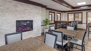 A dining area with granite tables and chairs, a fireplace, and a potted plant. - Best Western Mason Inn (Mason)