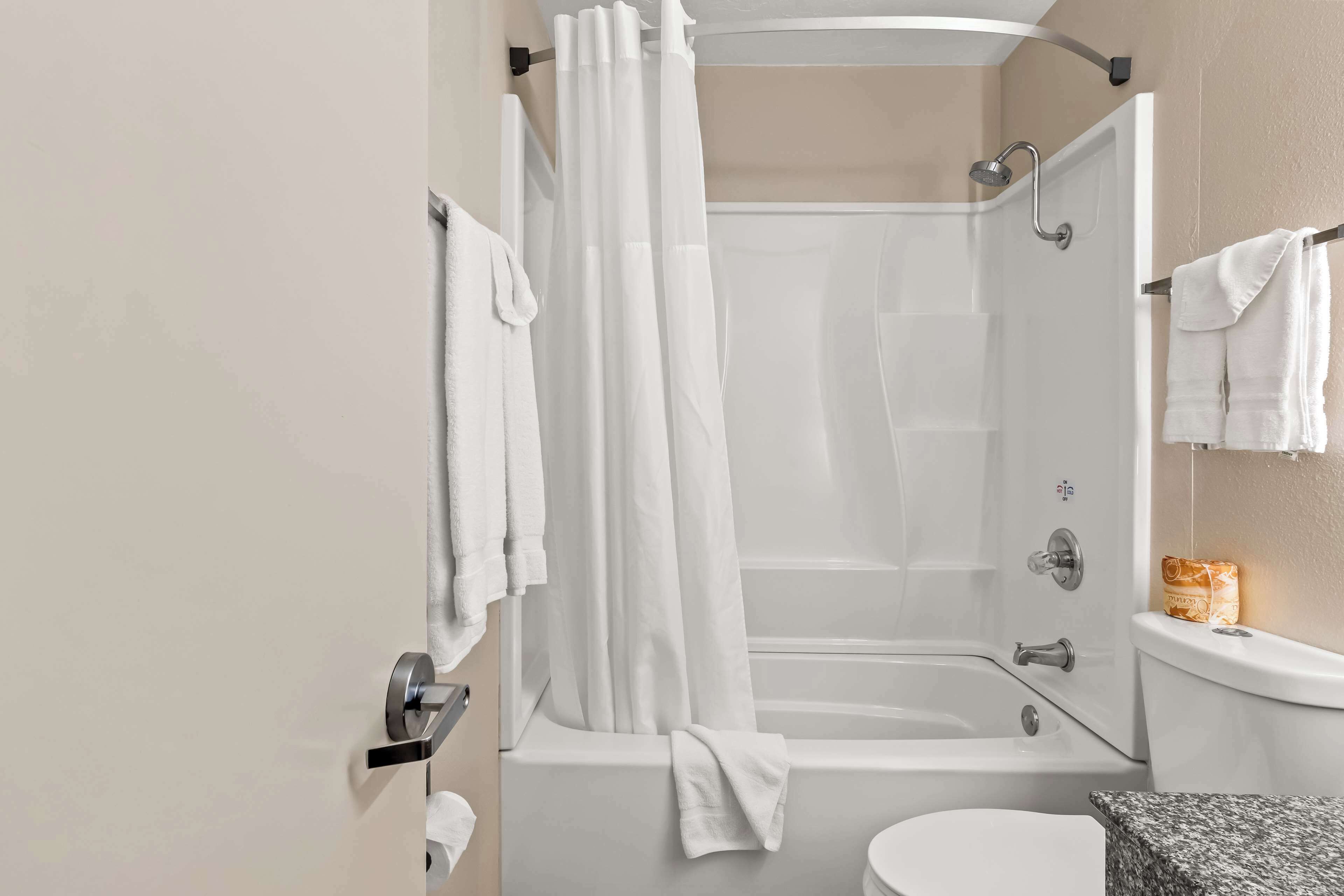 Un bagno moderno con vasca, WC e zona doccia.