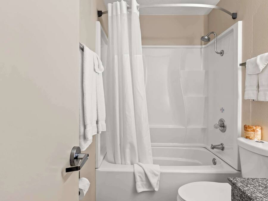 Un bagno moderno con vasca, WC e zona doccia.