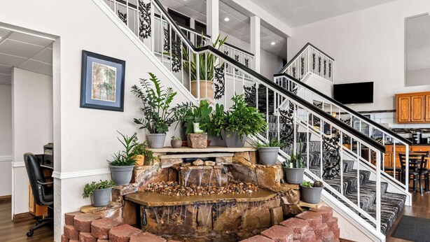 A staircase with a waterfall feature, surrounded by potted plants and a framed picture on the wall. - SureStay Hotel by Best Western Duncan (Duncan)