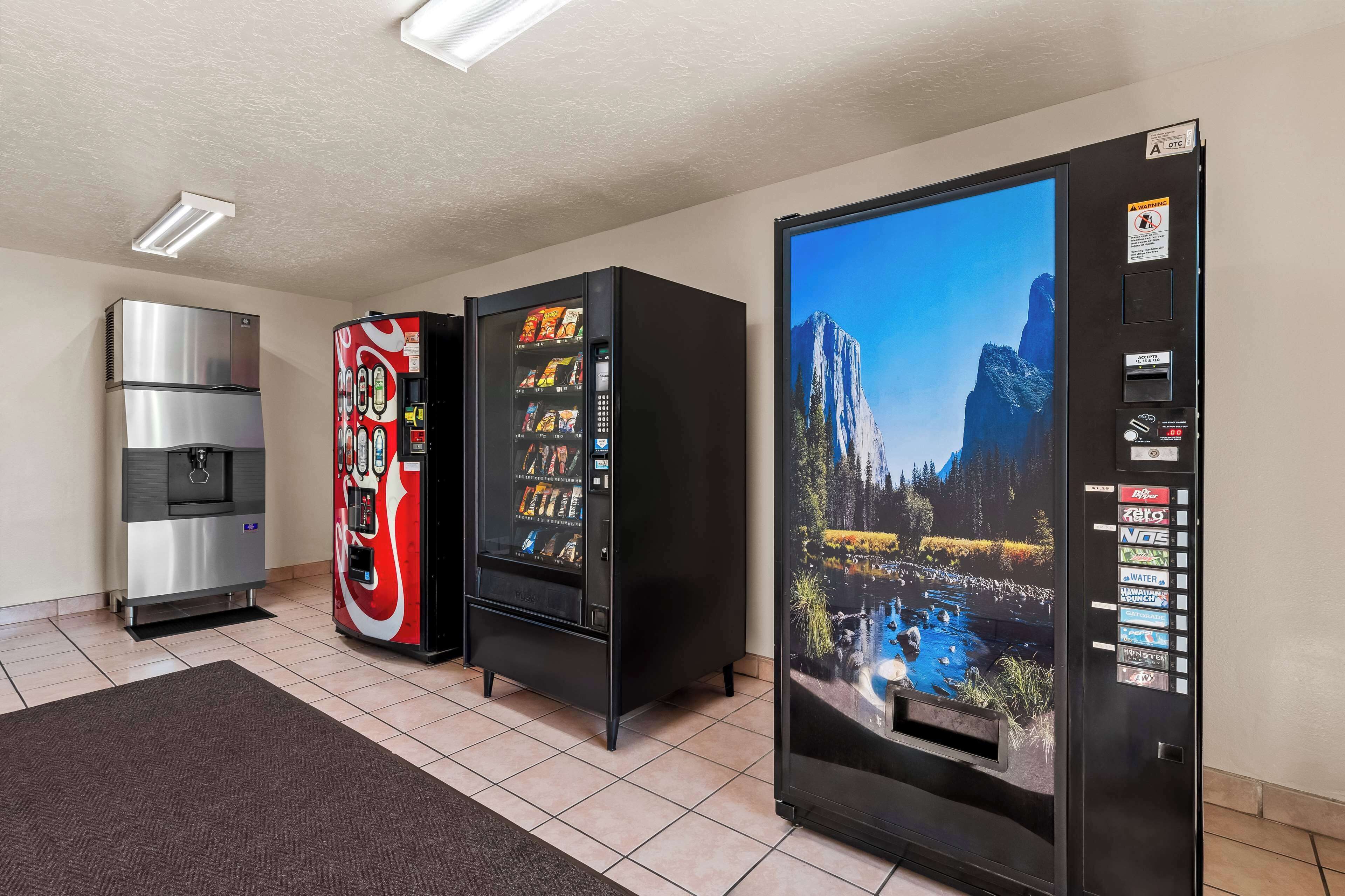 A room with a refrigerator, a vending machine, and a water dispenser.