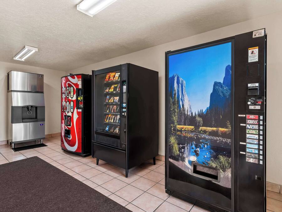 A room with a refrigerator, a vending machine, and a water dispenser.