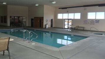 Una piscina techada, sillones reclinables de piscina