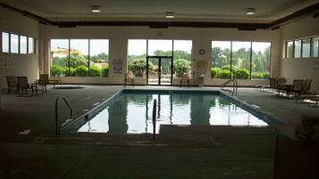 Piscina con vistas a árboles y una grúa en el exterior.