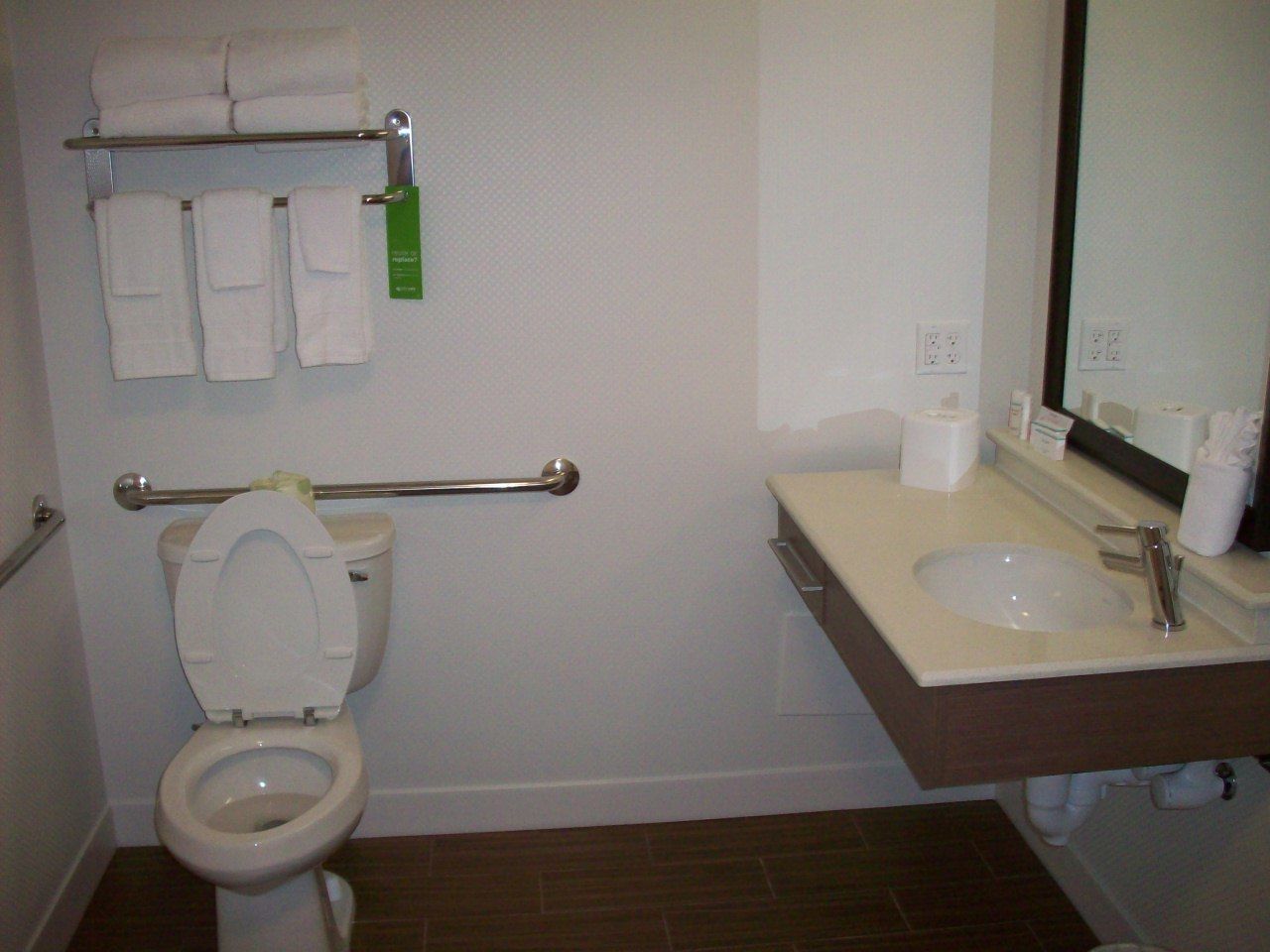 Une salle de bain équipée d’un WC, d’un lavabo, d’un miroir et d’un porte-serviettes avec des serviettes.