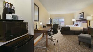 A hotel room with a bed, desk, chair, and a microwave. - Wingate Inn Chattanooga (Chattanooga)