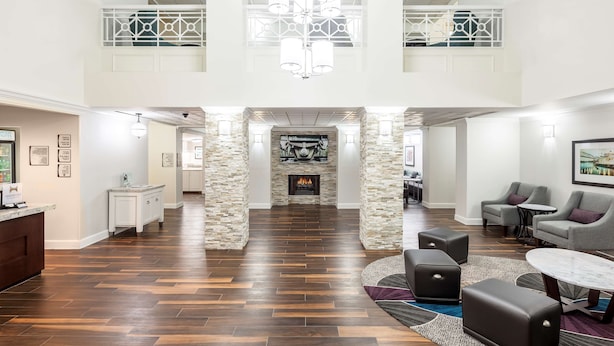 Un hall espacioso con chimenea, zona de estar y un techo alto con un aplique decorativo.