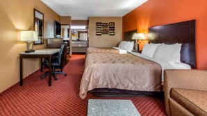 A hotel room with a bed, a desk, a chair, a TV, and a small table. - Quality Inn Kingston Springs (Kingston Springs)