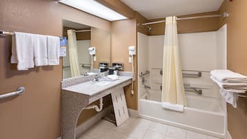 Un baño con ducha, lavamanos y espejo.