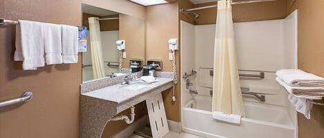 A bathroom with a shower, a sink, and a mirror.