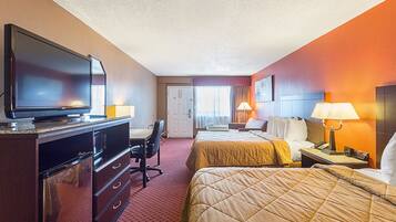 A hotel room with two beds, a desk with a chair, a television, and a microwave.
