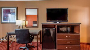 A hotel room with a desk, chair, television, refrigerator, microwave, and a framed picture on the wall. - Quality Inn Kingston Springs (Kingston Springs)