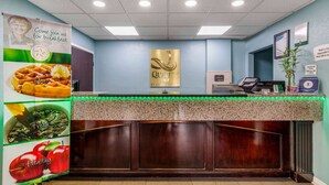 A hotel reception area with a counter, a sign for breakfast, and a wall-mounted menu board. - Quality Inn Kingston Springs (Kingston Springs)
