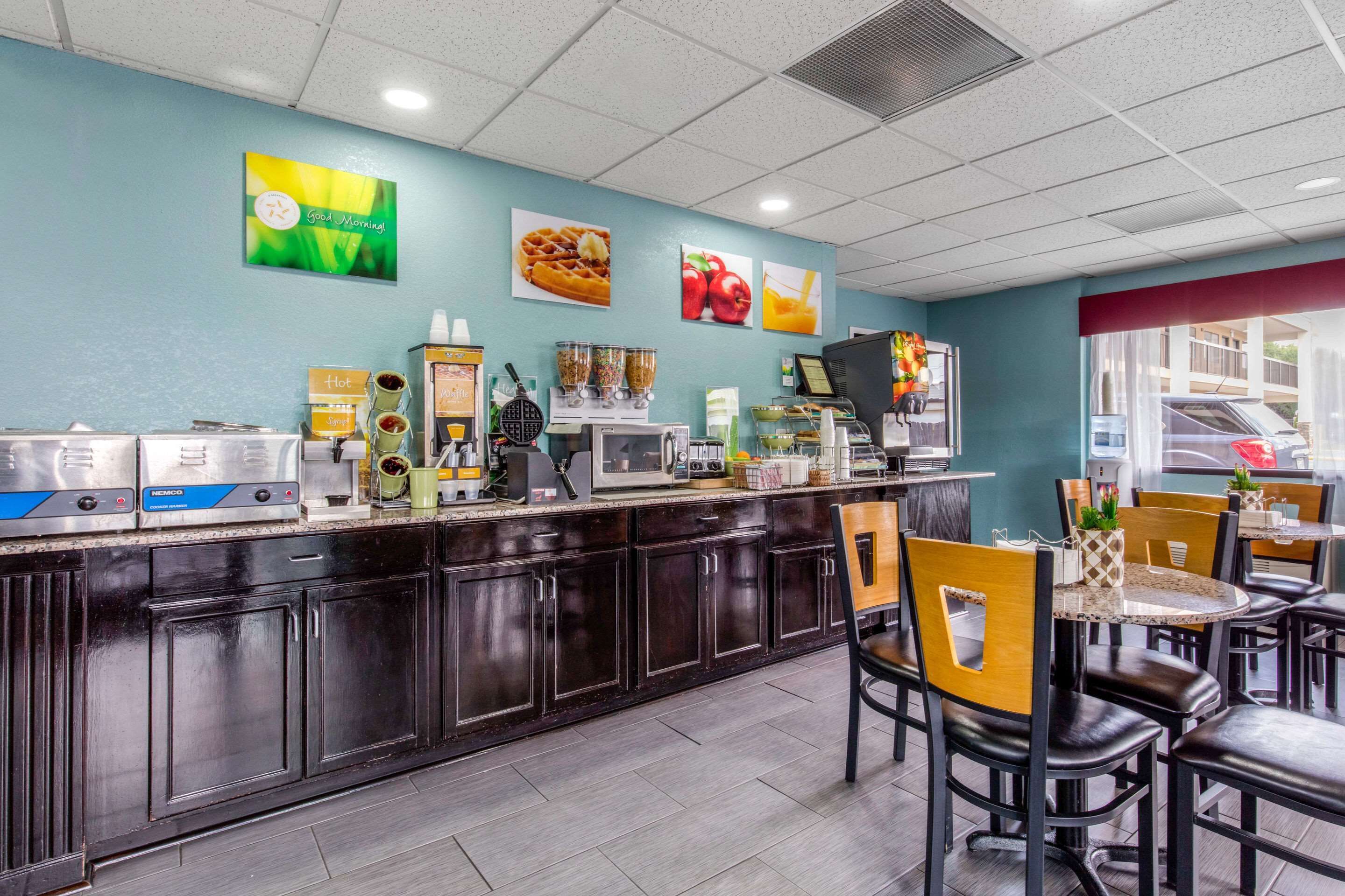 A breakfast bar with coffee machines, a microwave, and a fruit display.