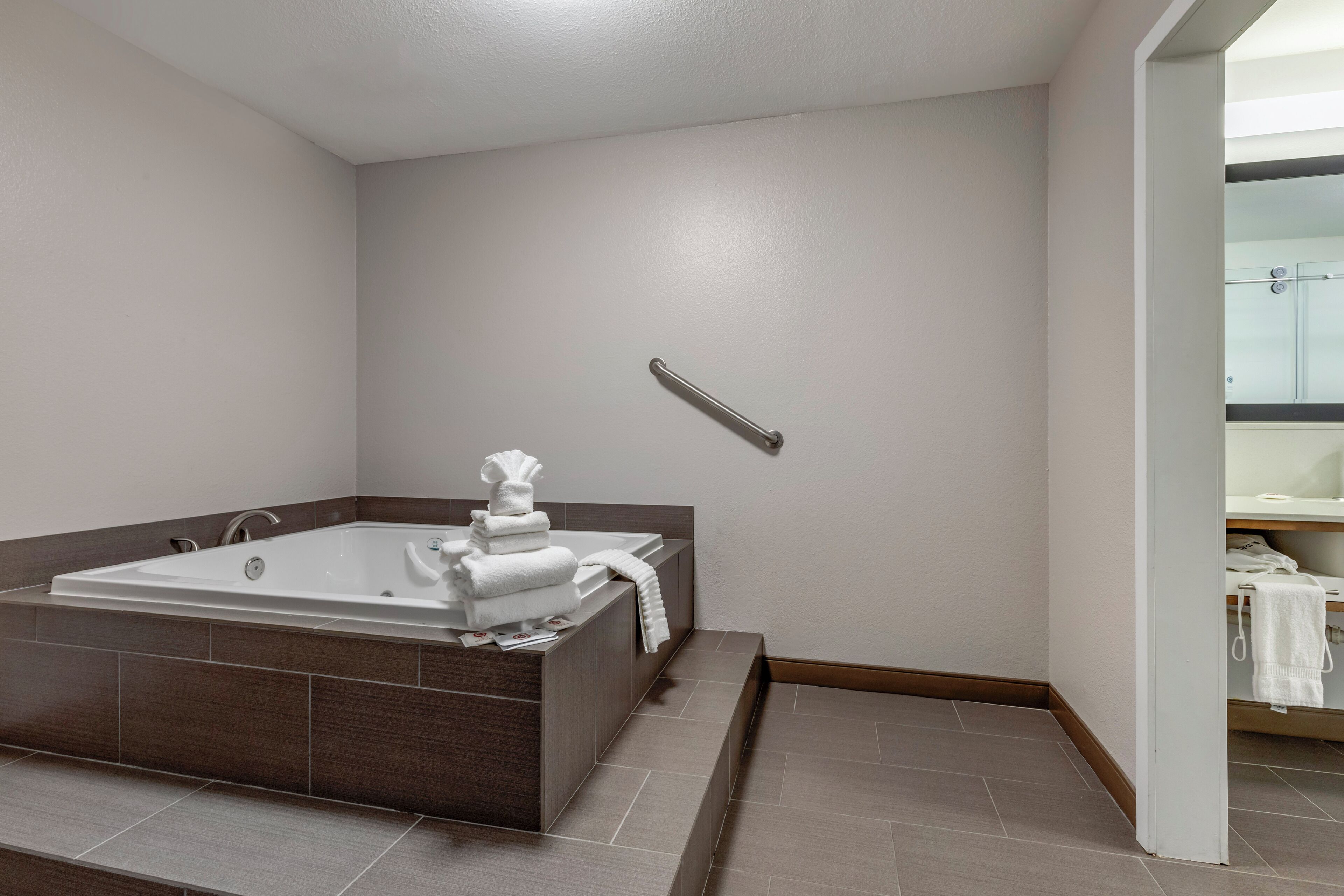 A modern bathroom with a large bathtub, a shower area, and a vanity with a mirror.