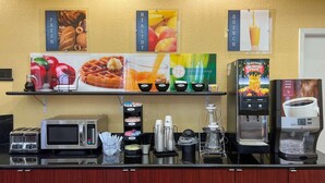 A breakfast bar with coffee machines, a microwave, and a display of fresh fruits and pastries. - Quality Inn & Suites Houston Northwest - Cypress (Houston)