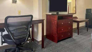 A hotel room with a desk, chair, TV, dresser, and lamp. - Quality Inn & Suites Houston Northwest - Cypress (Houston)