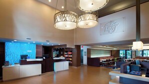 A spacious lobby with a reception desk, seating area, and a large wall with a logo.