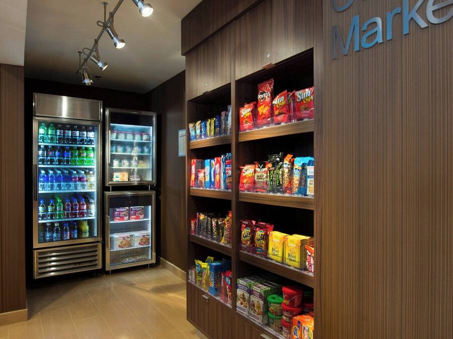 Een buurtwinkel met drankautomaten en schappen vol snacks en verpakte producten.