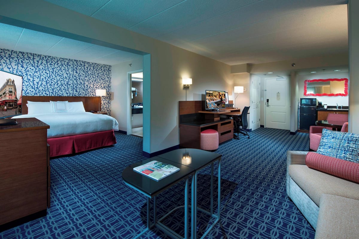 Une chambre d’hôtel avec un lit, un bureau, un canapé et une petite table.