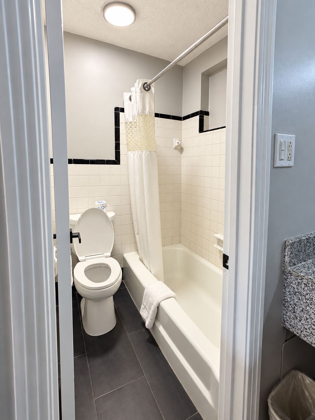 Un baño con inodoro, bañera y cortina de ducha.