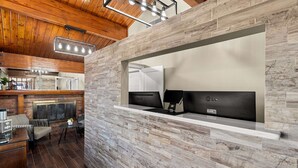 A modern kitchen with a built-in island, a fireplace, and a seating area with a table and chairs. - Rodeway Inn Dickson (Dickson)