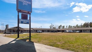 A motel named Rodeway Inn with a signboard, a parking lot, and a building with multiple rooms. - Rodeway Inn Dickson (Dickson)