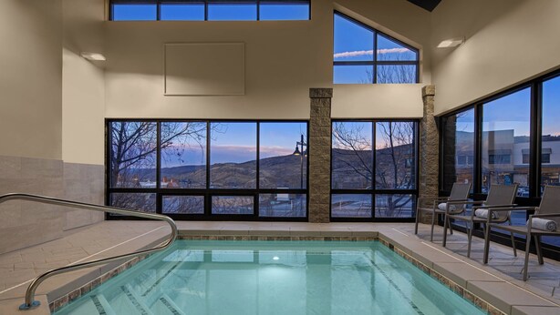 An indoor swimming pool with clear views of a mountainous landscape through large windows. - AC Hotel by Marriott Park City (Park City)