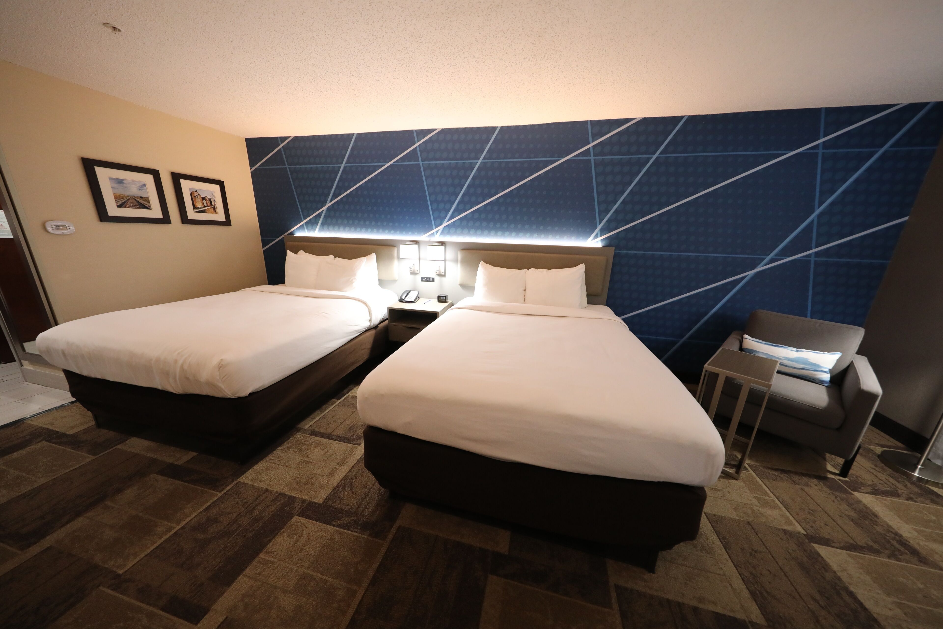Une chambre d’hôtel avec deux lits, une petite table et une chaise.
