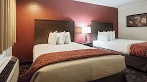 A hotel room with two beds, a nightstand, a lamp, and a painting on the wall. - Red Roof Inn Oklahoma Airport – I-40 W/Fairgrounds (Oklahoma City)