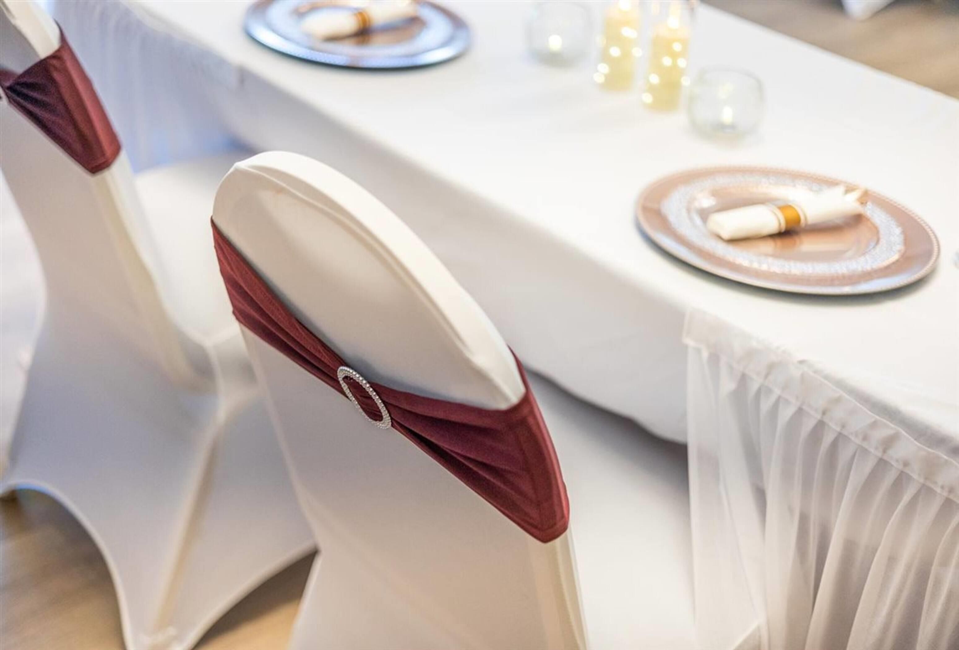 Una mesa servida con platos, servilletas y velas.