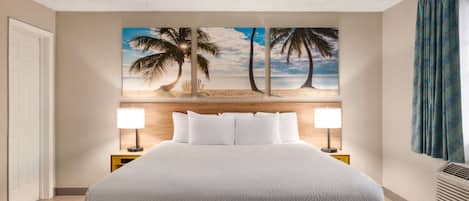 A hotel room with a large bed, a headboard with a painting of palm trees, two bedside lamps, and a window with curtains.