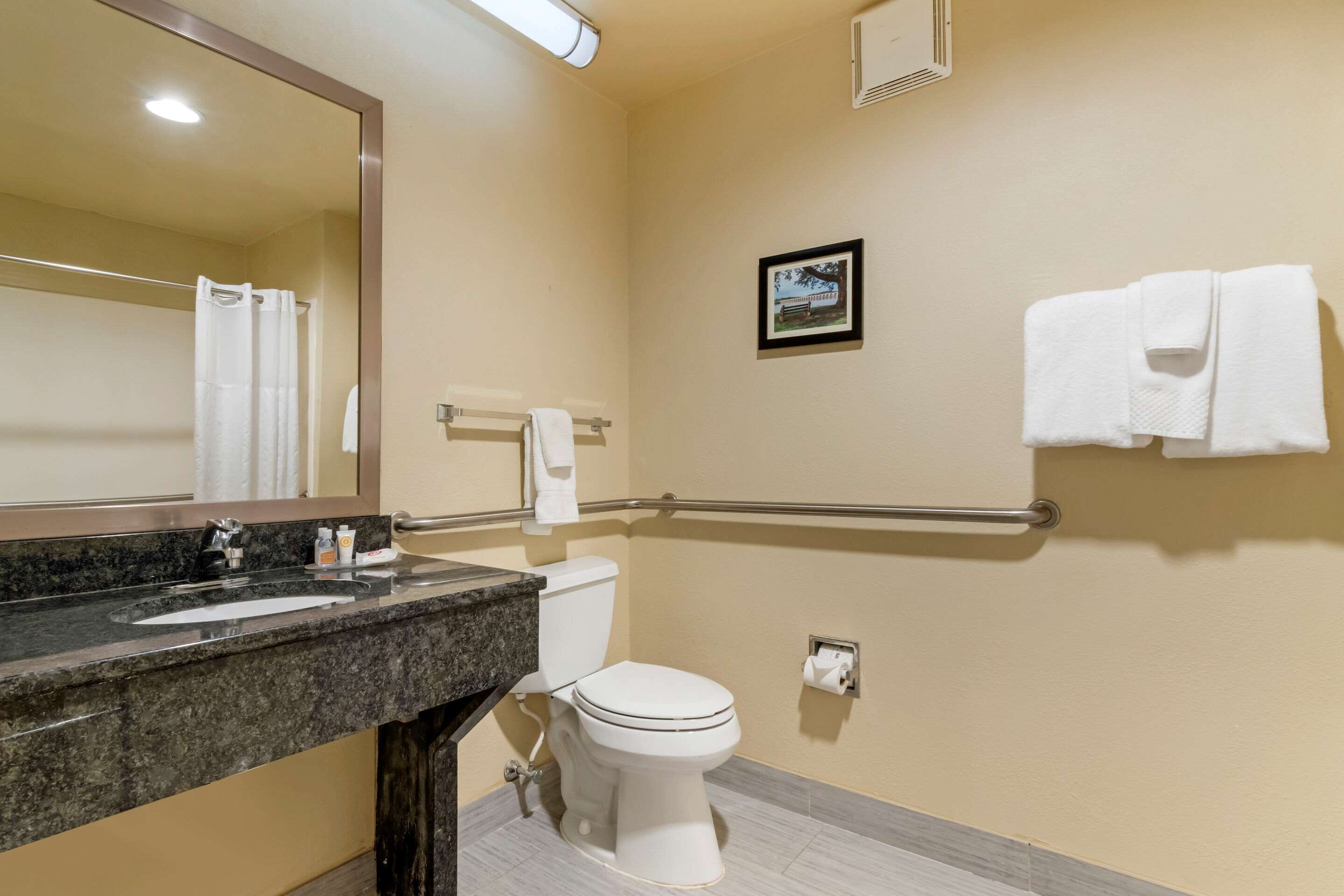 A bathroom with a sink, toilet, and a towel rack.
