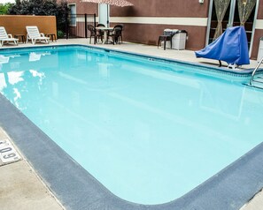 Una piscina al aire libre de temporada, tumbonas