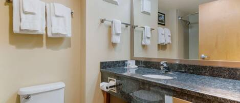 Une salle de bain équipée d’un WC, d’un lavabo, d’un miroir et d’un porte-serviettes.