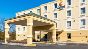 A Comfort Inn hotel with a covered parking area and a clear blue sky.
