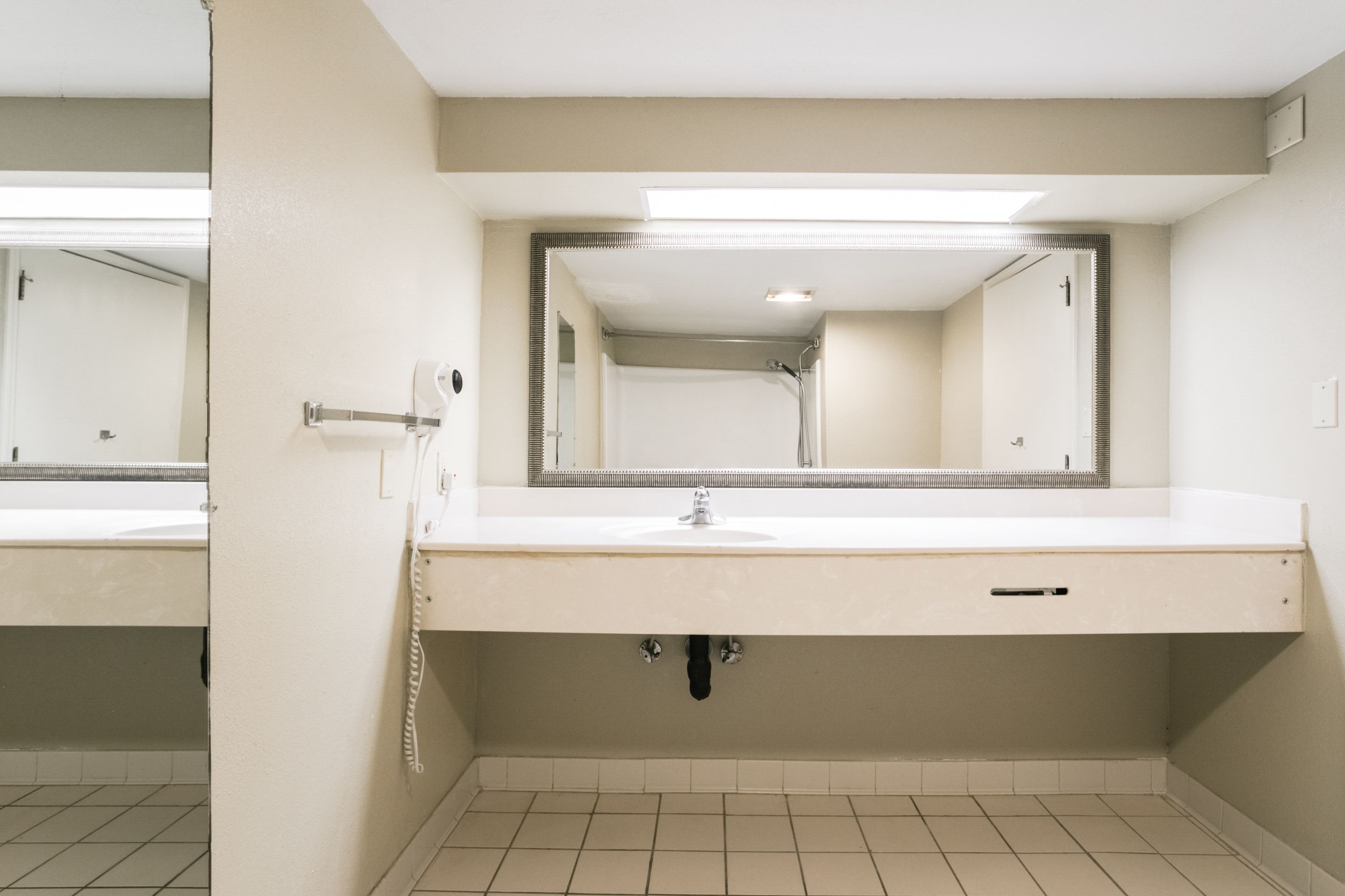 A bathroom with a white sink, a mirror, and a toilet.