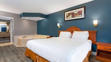 Habitación de hotel con una cama grande, cabecera de madera, bañera y un cuadro en la pared.